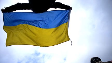 Un homme brandit un drapeau ukrainien &agrave; Kiev (Ukraine), le 17 avril.&nbsp; (KIRILL KUDRYAVTSEV / AFP)