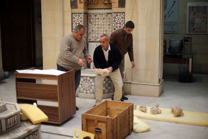 Des employés du musée de Damas emballent des statues antiques avant de les entreposer dans des boîtes (24 mars 2015)
 (Joseph Eid / AFP)