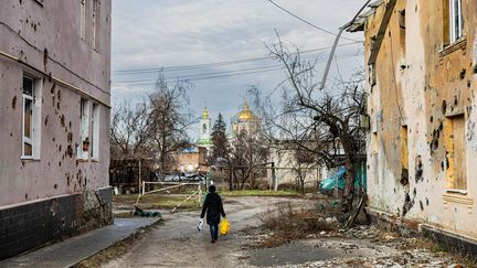 Un habitant de la ville d'Izioum au milieu des bâtiments endommagés, le 2 janvier 2023. (SAMEER AL-DOUMY / AFP)