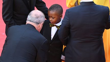 C'est l'heure des présentations entre Pierre Lescure et le jeune Milan Doucansi ("Un petit frère") qui fait&nbsp;sa première montée des marches. (ANTONIN THUILLIER / AFP)