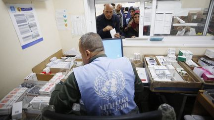 Un agent de l'UNRWA distribue des médicaments à des patients gazaouis à Gaza, le 21 janvier 2024. (ASHRAF AMRA / AFP)