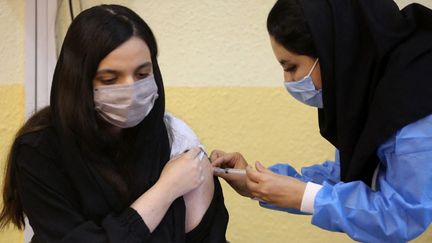 Une femme reçoit une dose de vaccin anti-Covid-19, à Téhéran, la capitale iranienne, le 8 octobre 2021. (FATEMEH BAHRAMI / ANADOLU AGENCY / AFP)