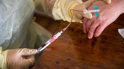 Un médecin pratique un test sérologique sur un patient volontaire, le 7 avril 2020, à Munich (Allemagne). (PETER KNEFFEL / DPA / AFP)