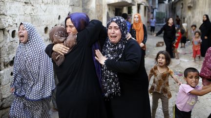 Des femmes palestiniennes pleurent apr&egrave;s la mort de quatre gar&ccedil;ons, tu&eacute;s le 16 juillet 2014 sur une plage de la bande de Gaza (Isra&euml;l).&nbsp; (MOHAMMED ABED / AFP)