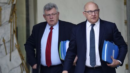 Michel Sapin (D), ministre des Finances, et Christian Eckert (G), secrétaire d'Etat au Budget, quittent l'Elysée, à Paris, le 15 avril 2015. (ERIC FEFERBERG / AFP)