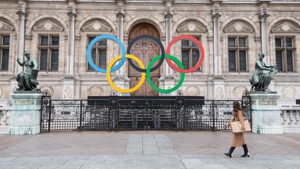 Les anneaux olympiques trônent devant l'Hôtel de ville de Paris, le 13 mars 2023. (ALAIN JOCARD / AFP)