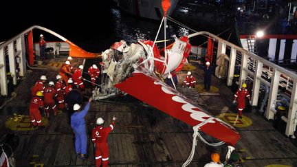 Une partie de la queue de l'avion d'AirAsia disparu en mer de Java, entrepos&eacute;e sur le pont d'un navire de sauvetage, le 11 janvier 2015. (DARREN WHITESIDE / REUTERS)