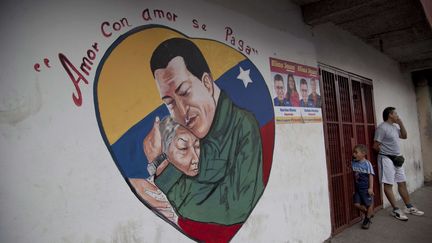 Dans le c&oelig;ur, le pr&eacute;sident v&eacute;n&eacute;zu&eacute;lien Hugo Chavez &eacute;treint une femme. "L'amour est r&eacute;compens&eacute; par l'amour", dit cette image photographi&eacute;e sur un mur de Caracas (Venezuela), le 4 janvier 2013. (ARIANA CUBILLOS / AP / SIPA)