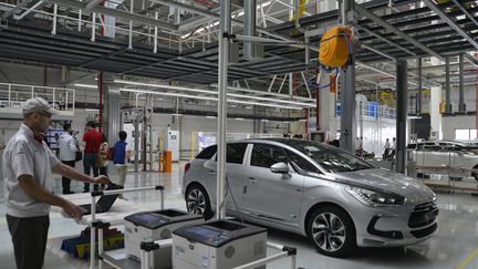 Un ouvrier regarde la DS5 de Citr&ouml;en en cours de fabrication dans l'usine&nbsp;PSA Peugeot Citroen de la province de Guangdong en Chine, le 28 septembre 2013. ( AFP )