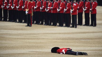 Un garde royal s'écroule, le 11 juin 2016, lors d'une revue des troupes organisées pour les 90 ans de la reine Elizabeth II, à Londres (Royaume-Uni).&nbsp; (DYLAN MARTINEZ / REUTERS)