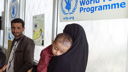 Une femme porte un enfant souffrant de malnutrition au centre de traitement du Programme alimentaire mondial, à Sanaa (Yémen), le 22 juin 2019. (MOHAMMED HUWAIS / AFP)