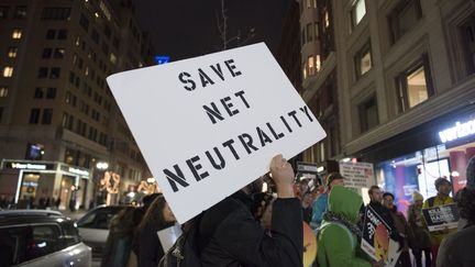 Un manifestant avec une pancarte "sauvez la neutralité du Net" à Boston, aux États-Unis, le 7 décembre 2017. (RYAN MCBRIDE / AFP)