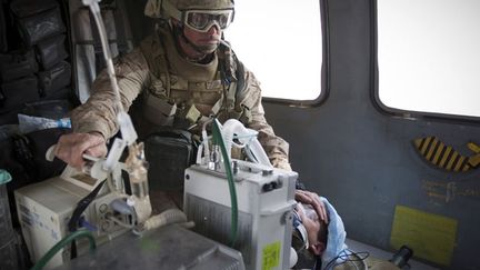 Le lieutenant-commandant James Gennari prend en charge le soldat. (AFP PHOTO / BEHROUZ MEHRI)