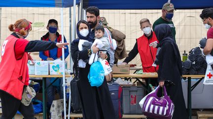 Des réfugiés afghans sur la base aérienne américaine de Ramstein (Allemagne), le 26 août 2021. (ARMANDO BABANI / AFP)