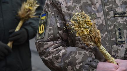 Un soldat ukrainien participe à une procession organisée à Lviv, dans l'ouest du pays, le 24 décembre 2023. Pour prendre leurs distances avec la tradition orthodoxe russe, qui célèbre Noël le 7 janvier, des Ukrainiens ont adopté cette année le calendrier grégorien. (PAVLO PALAMARCHUK / ANADOLU / AFP)