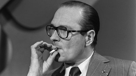 Jacques Chirac fume une cigarette, lors d'une réunion politique, à Paris, le 17 juin 1975.&nbsp; (GEORGES BENDRIHEM / AFP)