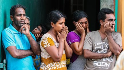 Des&nbsp;Sri Lankais&nbsp;regardent les forces de sécurité inspecter un véhicule suspect&nbsp;au lendemain des attentats, le 22 avril 2019, à Colombo (Sri Lanka).&nbsp; (CHAMILA KARUNARATHNE / ANADOLU AGENCY / AFP)