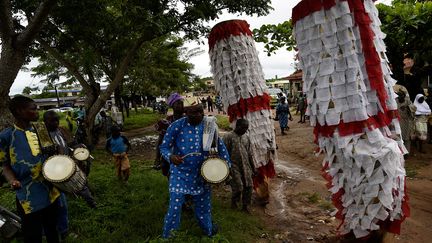 Ce festival fait la fierté de la région. Les jumeaux paradent dans les rues sous les chants et les regards des spectateurs. Et les "mascarades", personnages censés représenter les esprits, défilent en rythme, au son des percussions. (PIUS UTOMI EKPEI / AFP)