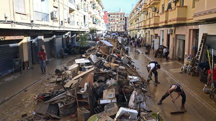 Des débris sont empilés au milieu de la rue, à Paiporta. (JOSE JORDAN / AFP)