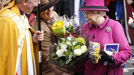 Le reine Elizabeth&nbsp;d'Angleterre (D) re&ccedil;oit un bouquet de fleurs lors d'une visite de la cath&eacute;drale de Leicester (Royaume-Uni), le 8 mars 2012. (DARREN STAPLES / REUTERS)