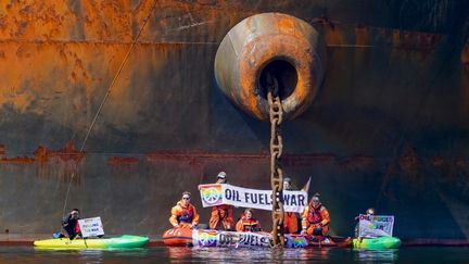 Des militants écologistes de Greenpeace organisent une action contre le navire "Ust Luga", dans le port d'Aasgaardstrand, en Norvège, le 25 avril 2022. (OLE BERG-RUSTEN / NTB / AFP)