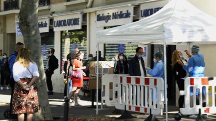 Des gens font la queue devant un laboratoire médical à Paris pour être dépisté contre coronavirus, le 18 juillet 2020. (BERTRAND GUAY / AFP)