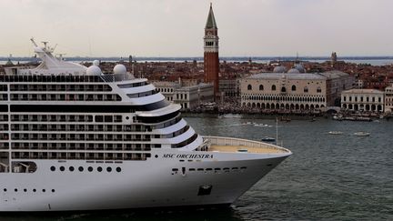 Un bâteau de croisière quitte Venise, en passant à côté de la Bell Tower et le palais des Doges, le 5 juin 2021. Les grands navires de ce type ne pourront plus entrer dans le centre de la ville à partir du 1er août 2021. (MIGUEL MEDINA / AFP)