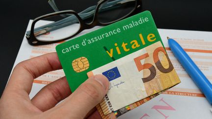 Une carte vitale avec un billet de 50 euros, à Clonas, en Isère, le 8 janvier 2024. (ROMAIN DOUCELIN / HANS LUCAS / AFP)