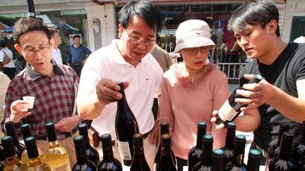 Des visiteurs chinois devant un stand de vins français, le 10 octobre 2008, à la 7e French Week de Shanghaï (Chine). (Shanghai Daily / Imaginechina )