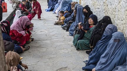 Femmes afghanes qui attendent de recevoir du pain par charité au moment du mois sacré du ramadan en avril 2023 (WAKIL KOHSAR / AFP)