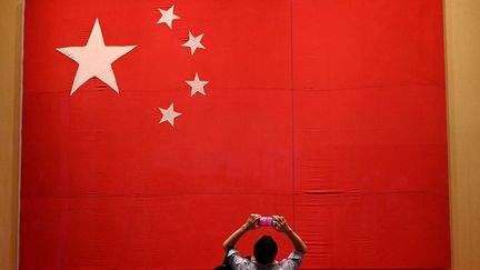 Un journaliste prend en photo le drapeau chinois le 25 juin 2021. Photo d'illustation. (NOEL CELIS / AFP)