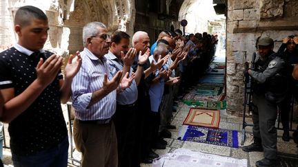 Des Palestiniens prient à l'extérieur de l'esplanade des Mosquées, le 26 juillet 2017, à Jérusalem. (RONEN ZVULUN / REUTERS)