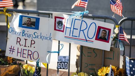 Des pancartes en hommage au policier Brian Sicknick, tué lors de l'invasion de militants pro-Trump au Congrès, le 10 janvier 2021. (AL DRAGO / GETTY IMAGES NORTH AMERICA / AFP)