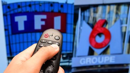 Une télécommande devant les logos des chaînes TF1 et M6. (photo d'illustration) (ROMAIN DOUCELIN / HANS LUCAS / AFP)