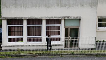 Une policière devant l'école maternelle Jean Perrin d'Aubervilliers (Seine-Saint-Denis), où un enseignant a été agressé à l'arme blanche, le 14 décembre 2015. (JACQUES DEMARTHON / AFP)