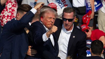 L'ex-président américain Donald Trump blessé à l'oreille après une tentative d'assassinat au cours d'un meeting, à Butler, en Pennsylvanie (Etats-Unis), le 13 juillet 2024. (REBECCA DROKE / AFP)