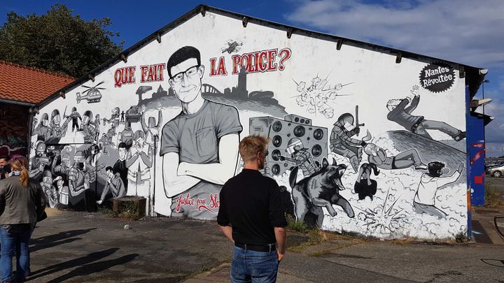 L'un des artistes qui ont réalisé la fresque à l'entrée du quai Wilson, à Nantes (Loire-Atlantique), le 18 juin 2020.&nbsp; (FABIEN MAGNENOU / FRANCEINFO)