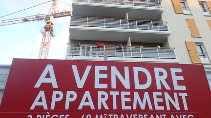 Pancarte posée par une agence immobilière devant un immeuble neuf à Ermont (Val-d'Oise). (VINCENT ISORE / MAXPPP)