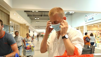 Un homme met un masque dans un supermarché. (VANESSA MEYER / MAXPPP)