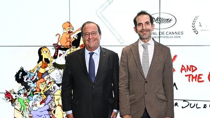 Cartoonist Jul, on the right, alongside François Hollande, who lends his voice to one of the characters in the film, "Silex and the city". (STEPHANE CARDINAL - CORBIS / CORBIS ENTERTAINMENT)