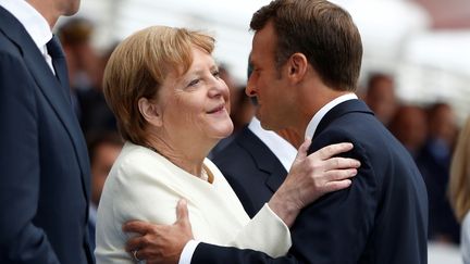 La chancelière allemande Angela Merkel et Emmanuel Macron, dimanche 14 juillet 2019 à Paris. (Kamil Zihnioglu / REUTERS)