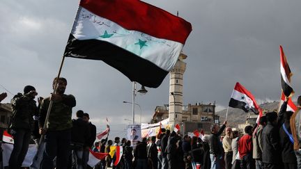 Des Syriens favorables au r&eacute;gime de Bachar Al-Assad agitent le drapeau de leur pays &agrave; Damas (Syrie), le 9 d&eacute;cembre 2011. (REUTERS)