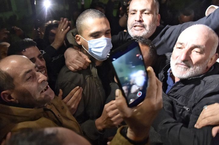 Le journaliste algérien,&nbsp;Khaled Drareni, accueilli par ses soutiens à sa sortie de la prison de Koléa, le 19 février 2021. (RYAD KRAMDI / AFP)