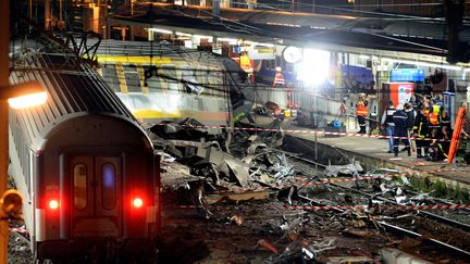 Des équipes de secours sur le site de l'accident ferroviaire en gare de Brétigny-sur-Orge (Essonne), le 12 juillet 2013. (LIONEL BONAVENTURE / AFP)