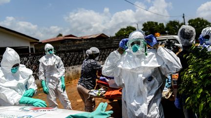 Des membres de la Croix-Rouge portent le corps d'une victime du virus Ebola, &agrave; Monrovia au Liberia, le 10 octobre 2014. (MOHAMMED ELSHAMY / ANADOLU AGENCY / AFP)