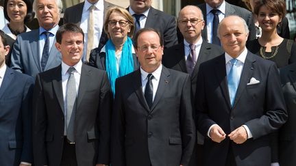 De g. &agrave; dr., au premier plan, le Premier ministre, Manuel Valls, le pr&eacute;sident, Fran&ccedil;ois Holande et le ministre des Affaires &eacute;trang&egrave;res,&nbsp; Laurent Fabius, participent &agrave; la photo du gouvernement, &agrave; l'Elys&eacute;e, le 18 juin 2014. (VILLARD / SIPA)