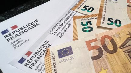 Taxe foncière et des billets de banque. (DENIS CHARLET / AFP)