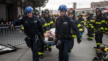 Des policiers et des pompiers évacuent des blessés après le déraillement d'un train à New York (Etats-Unis), le 4 janvier 2017. (DREW ANGERER / GETTY IMAGES NORTH AMERICA / AFP)