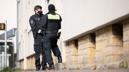 Des policiers se tiennent devant l'un des locaux perquisitionnés, à Osnabrück (Allemagne), le 6 novembre 2020. (FRISO GENTSCH / DPA / AFP)