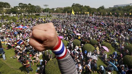 Un manifestant l&egrave;ve le poing apr&egrave;s &ecirc;tre entr&eacute; dans les jardins de la r&eacute;sidence du gouvernement tha&iuml;landais &agrave; Bangkok (Tha&iuml;lande), le 3 d&eacute;cembre 2013. (WASON WANICHAKOM / AP / SIPA)